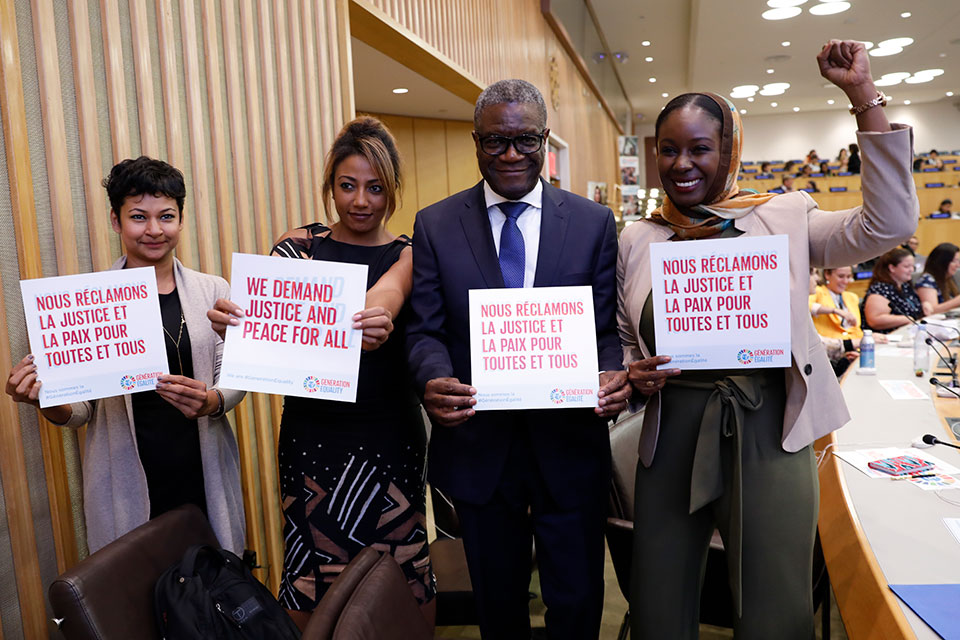 Members of the G7 Gender Equality Advisory Council Vanessa Mangour (left center) and Nobel Peace Prize Laureate Denis Mukwege (right center) and others show support for Generation Equality. Photo: UN Women/Ryan Brown